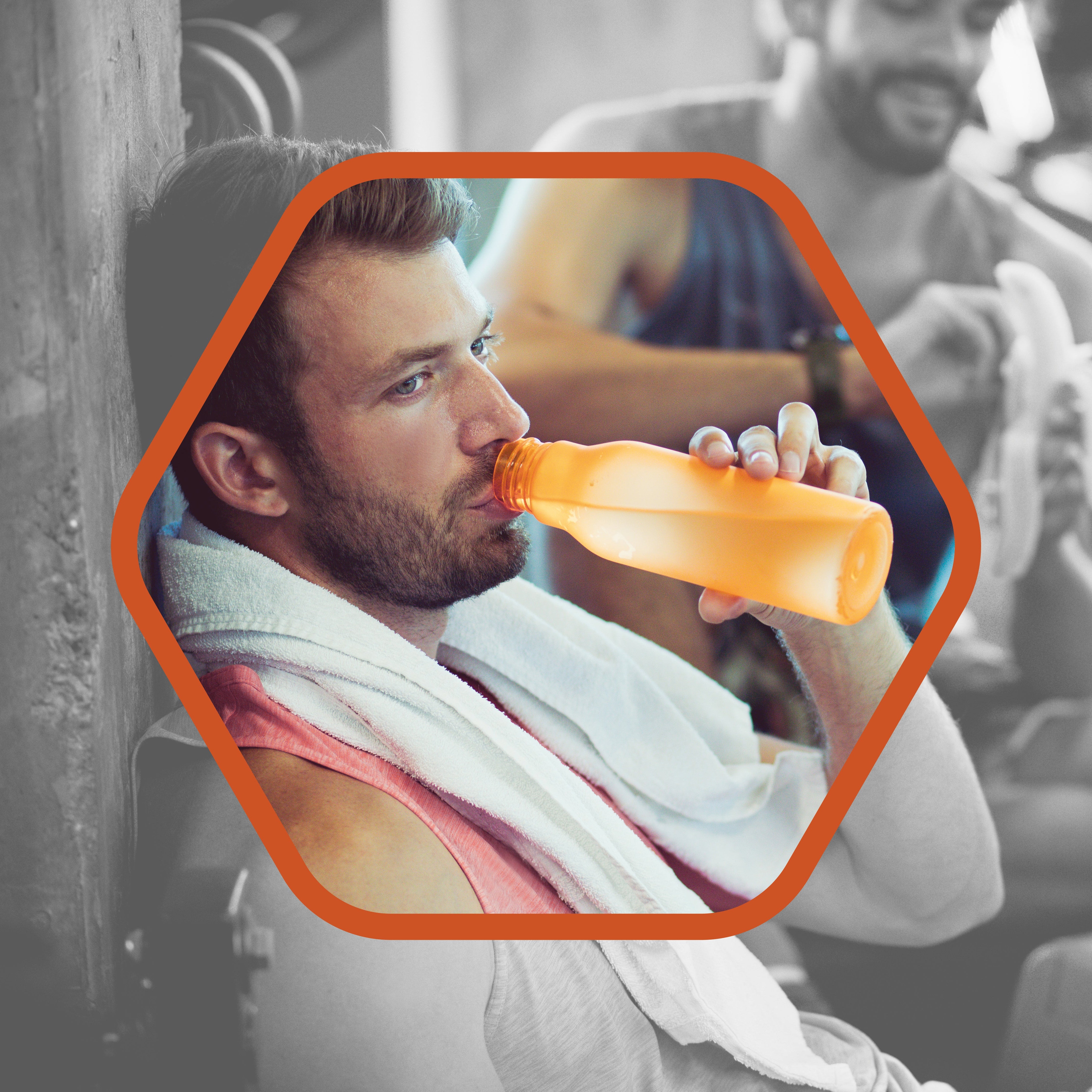 Man at gym drinking from a water bottle